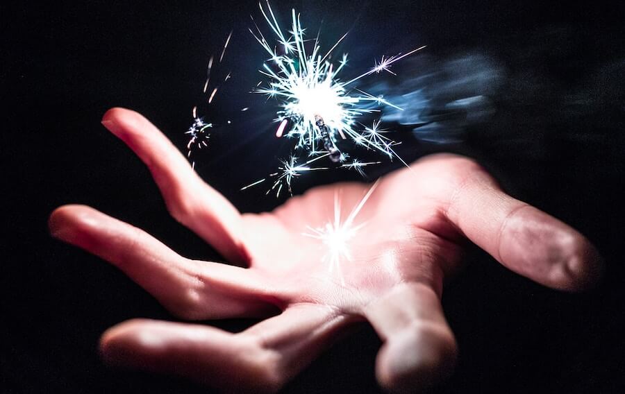 A spark floating above someone's palm